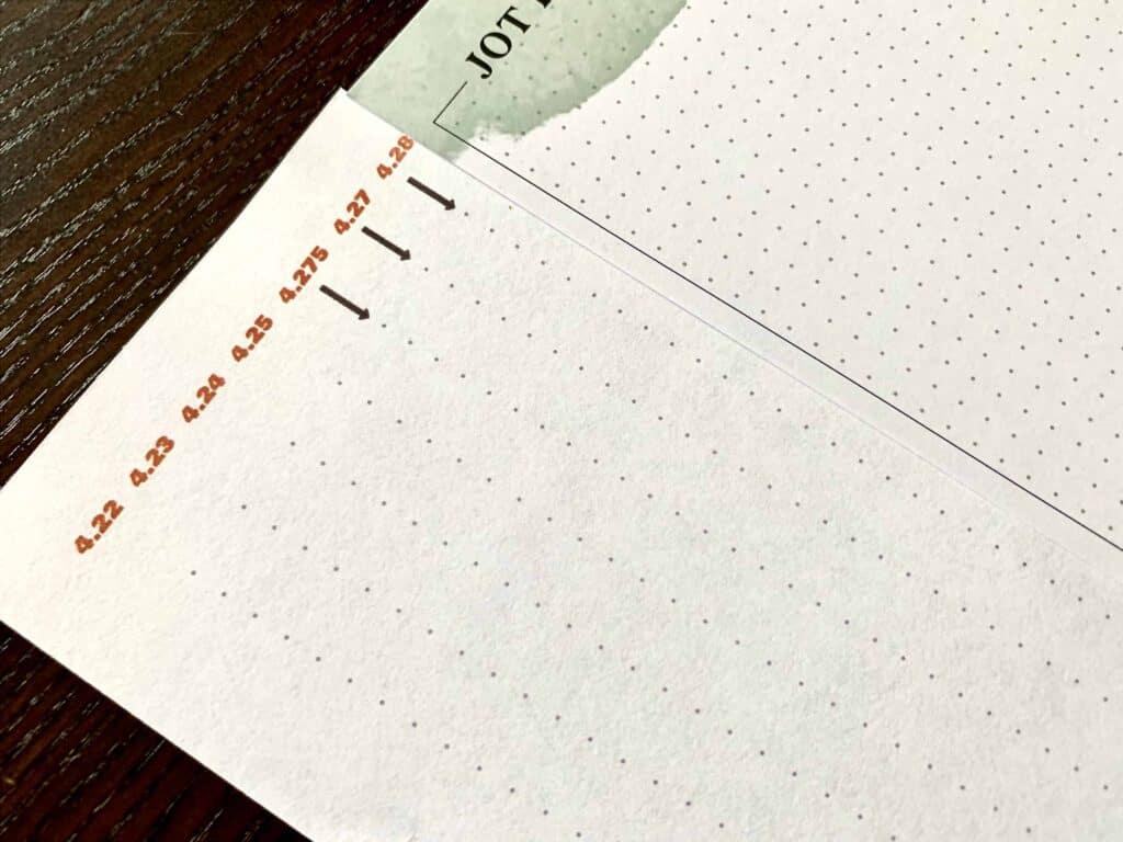 Closeup of dot grid spacing testing and one sheet of The Happy Planner dot grid paper